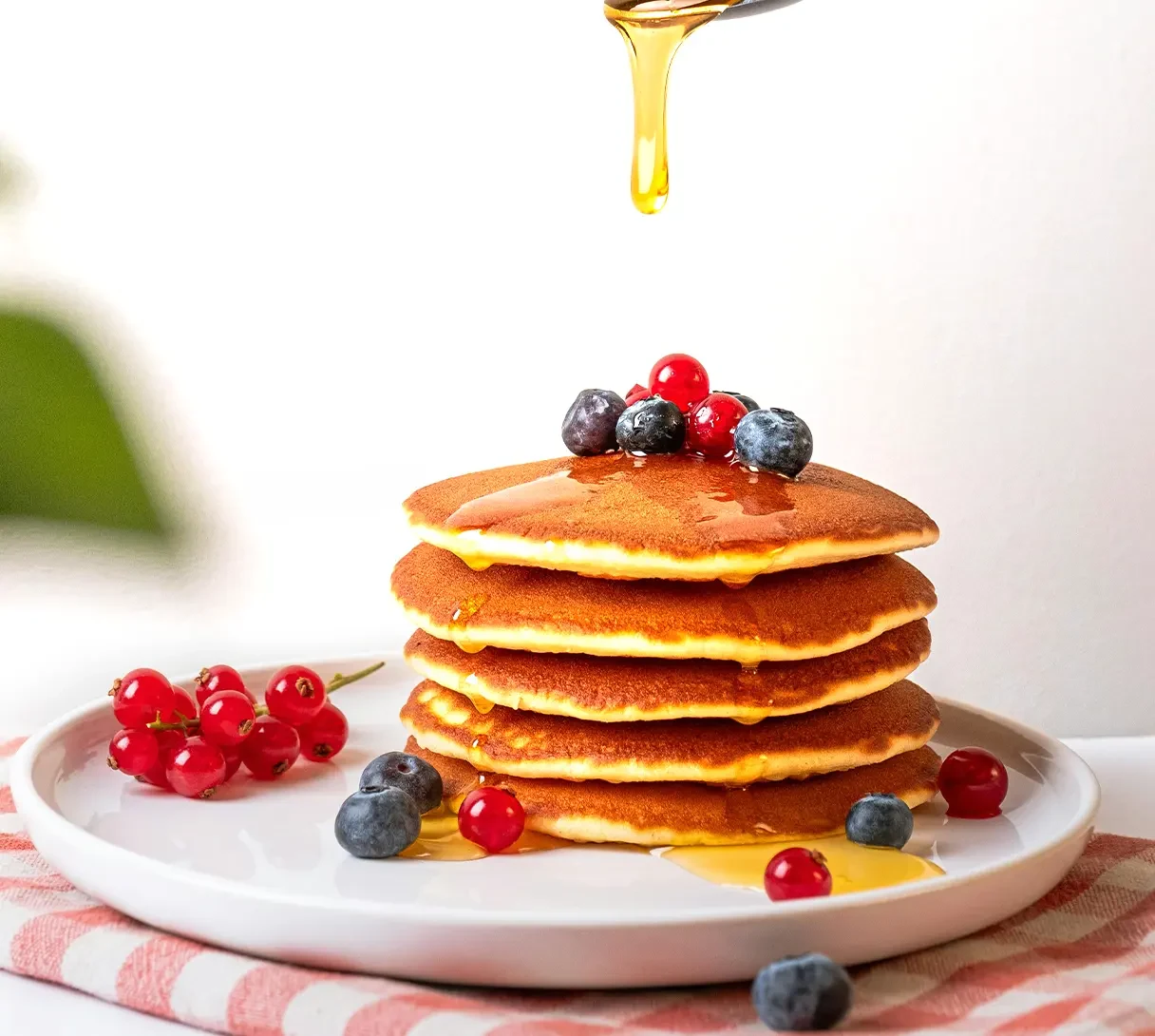 Henry's Honey organic honey being drizzled on pancakes